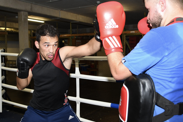 Zwei Boxer trainieren im Ring, einer schl&auml;gt mit einem rechten Jab auf den anderen ein, der einen Schild h&auml;lt.