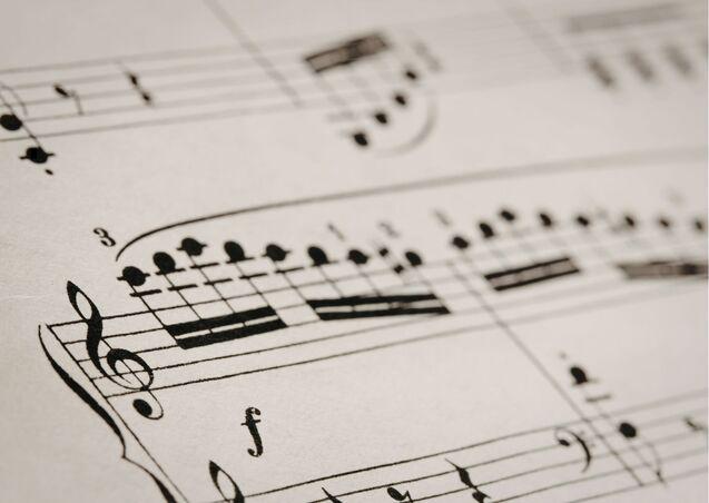 Nahaufnahme von Musiknoten auf einem Notenblatt mit verschiedenen Takten und Notenwerten.